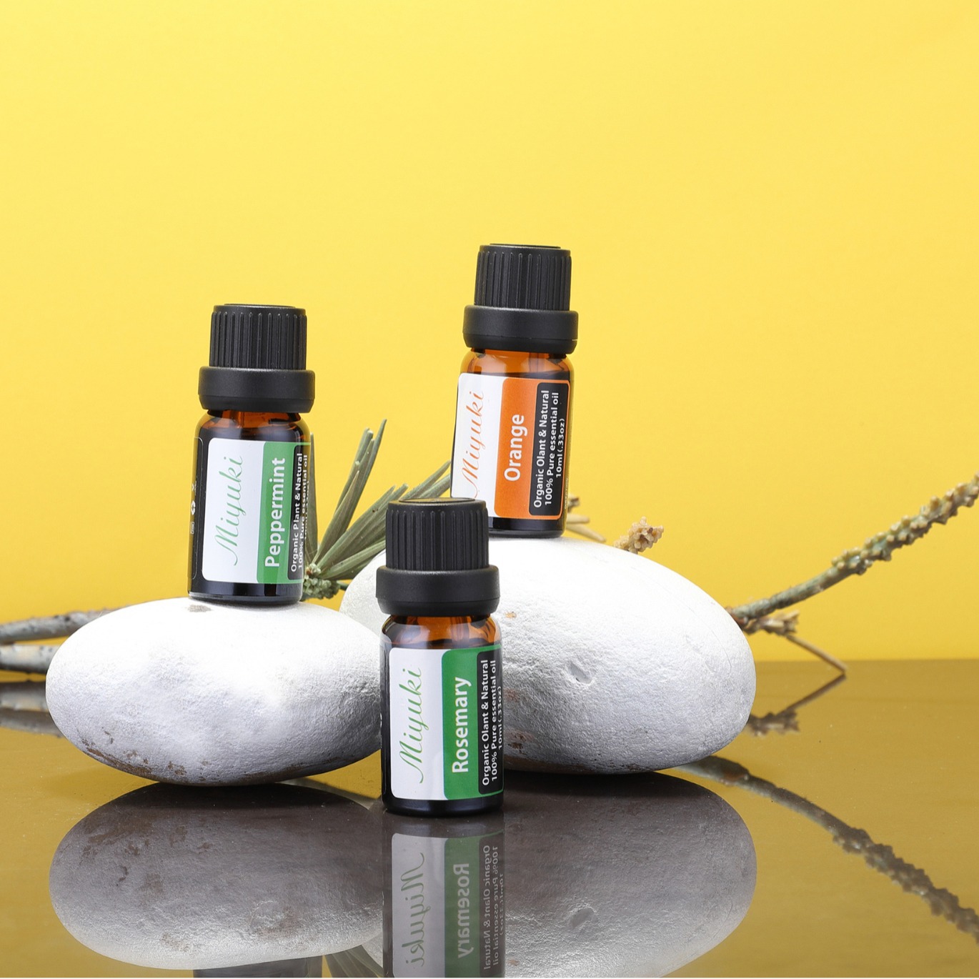 MIYUKI 10 ml bottles arranged on white stones against a yellow background